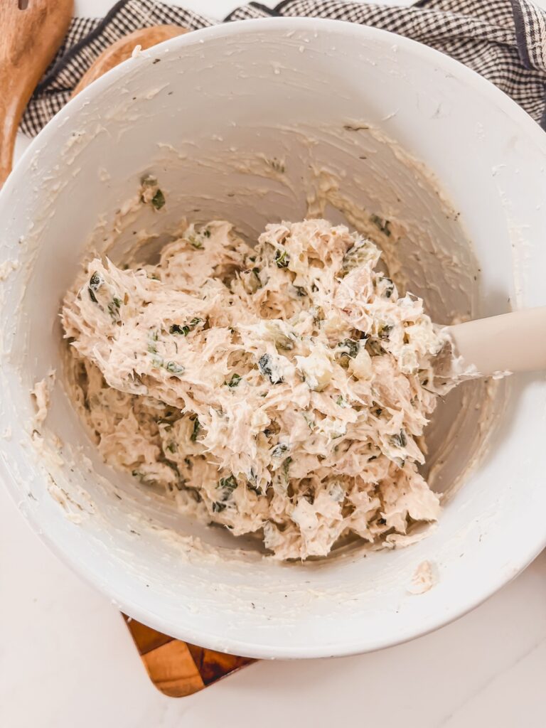 fully mixed chicken salad in white bowl