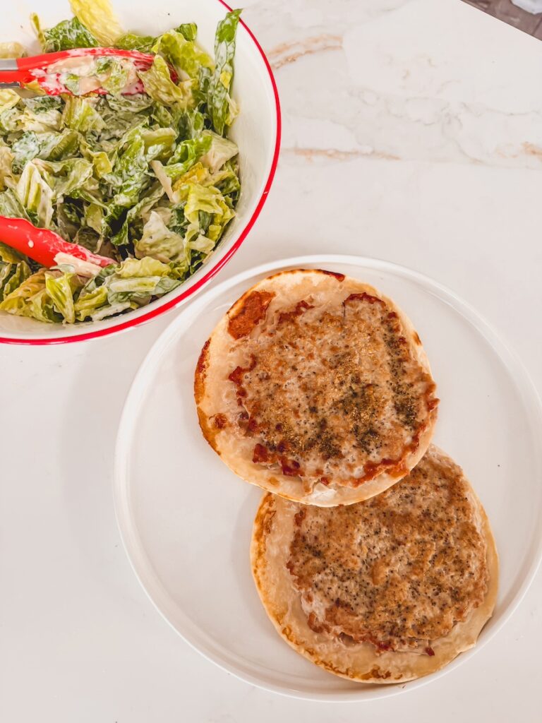 bowl of caesar salad next to smash tacos