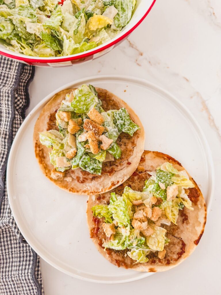 two smashed tacos on a white plate