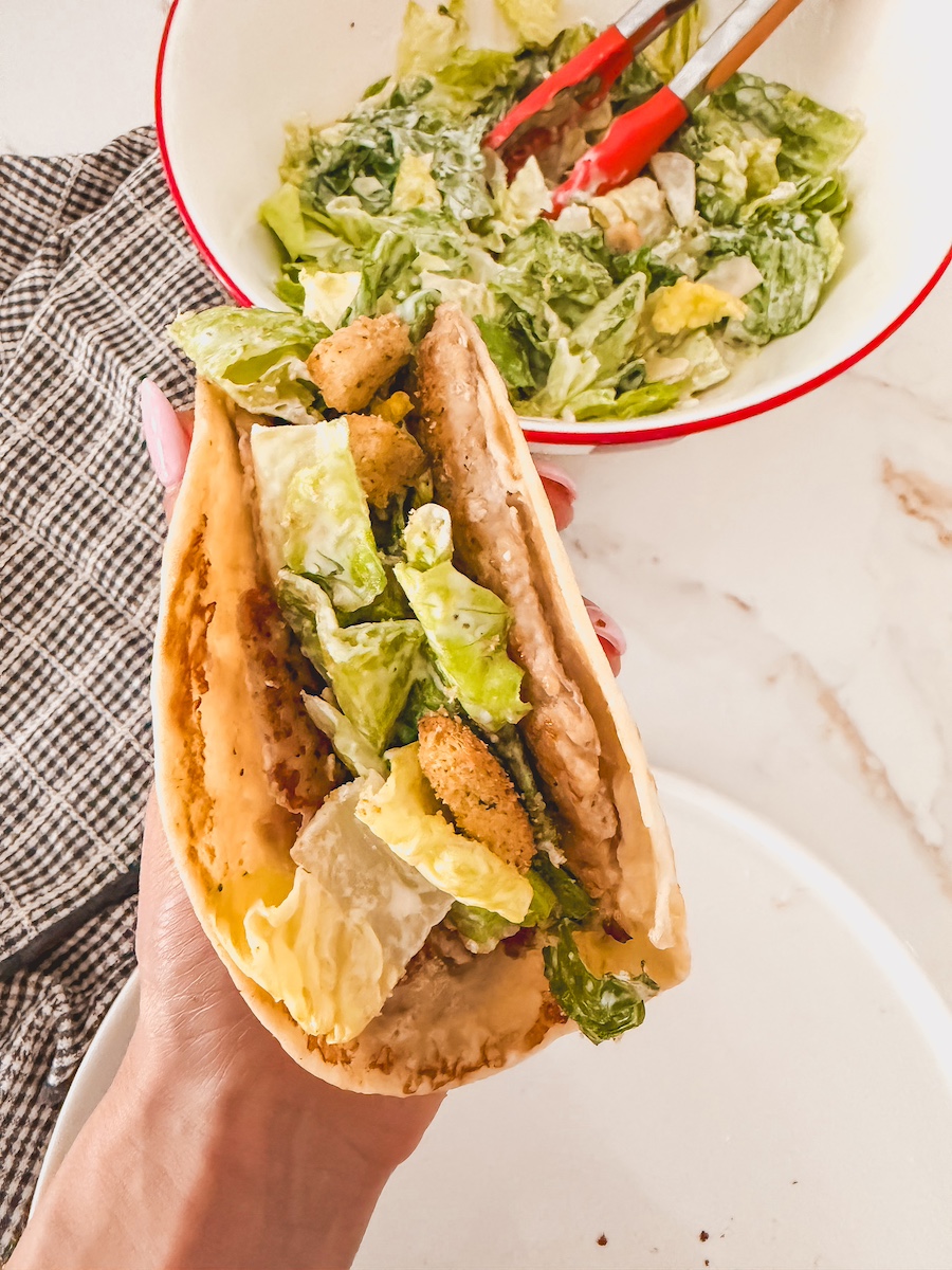 hand holding chicken caesar salad smashed taco
