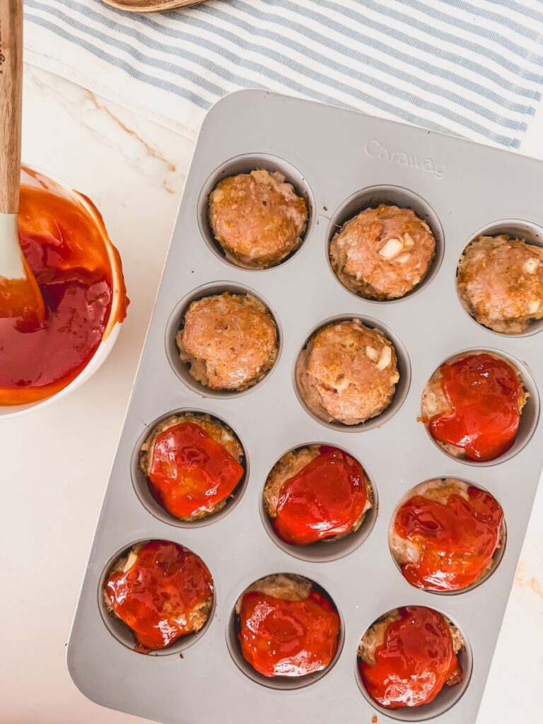 bowl of sauce next to muffin tin with meat mixture 