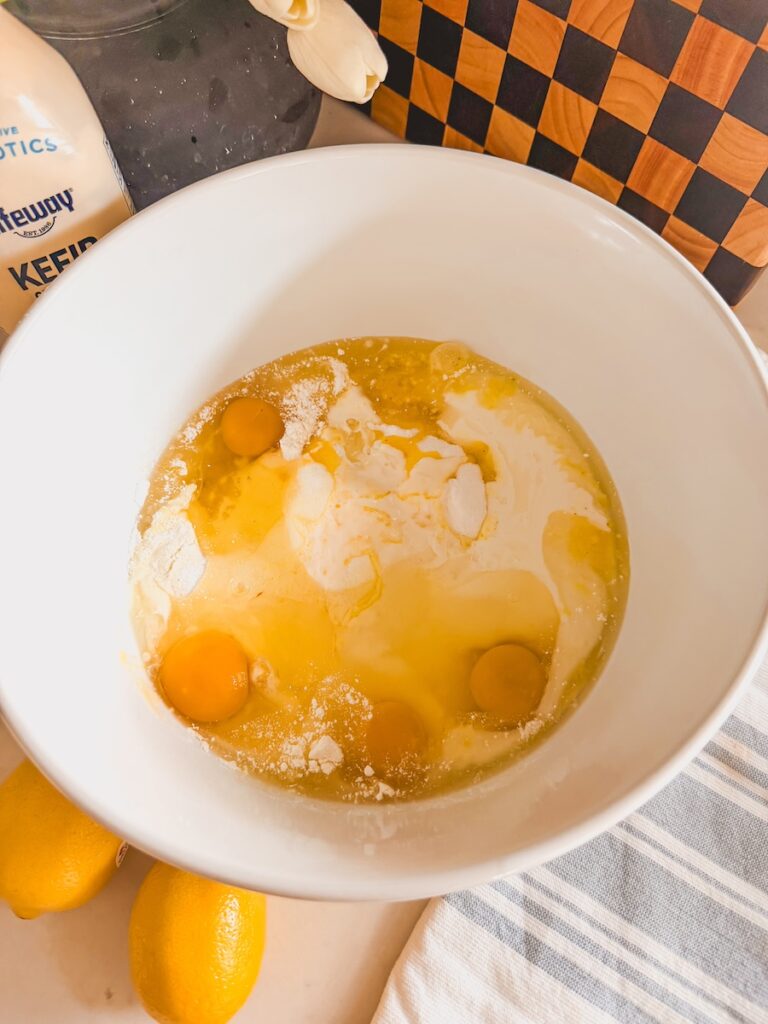 dry and wet cake ingredients in white bowl, unmixed