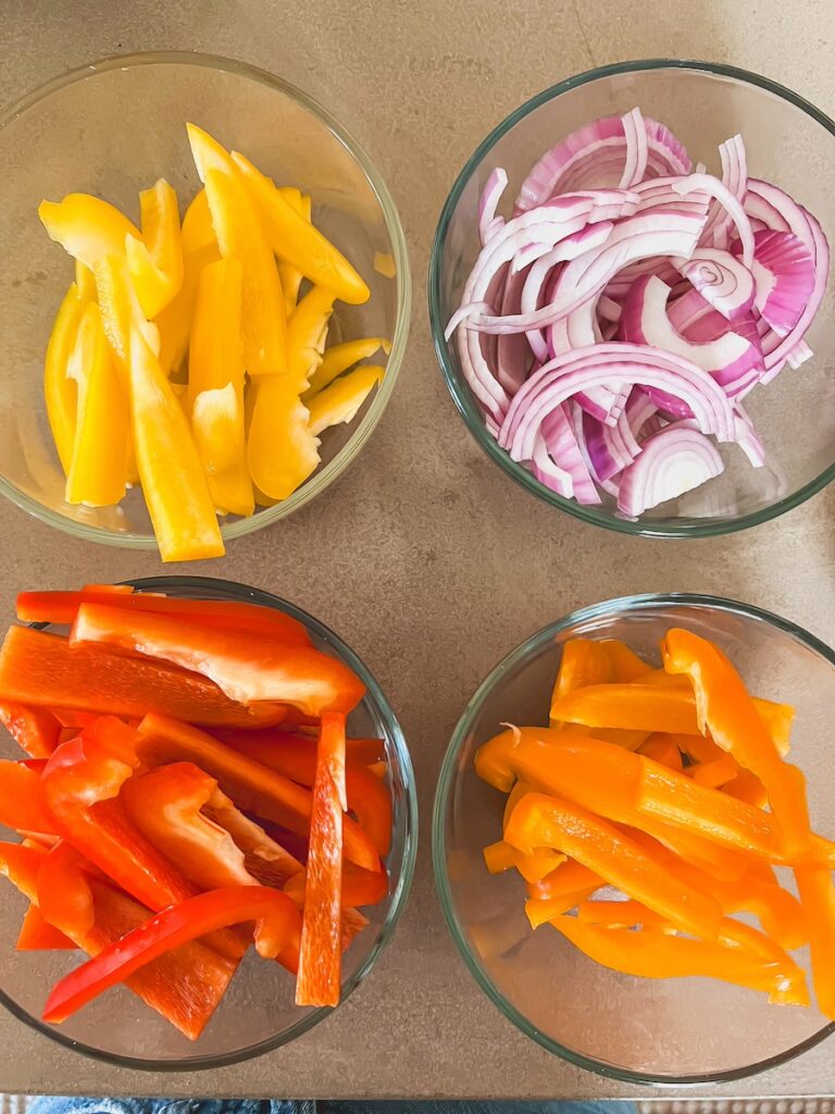 bell peppers and onions in clear bowls