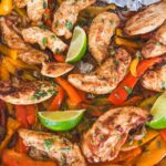 close up shot of sheet pan chicken fajitas and tortillas in corner