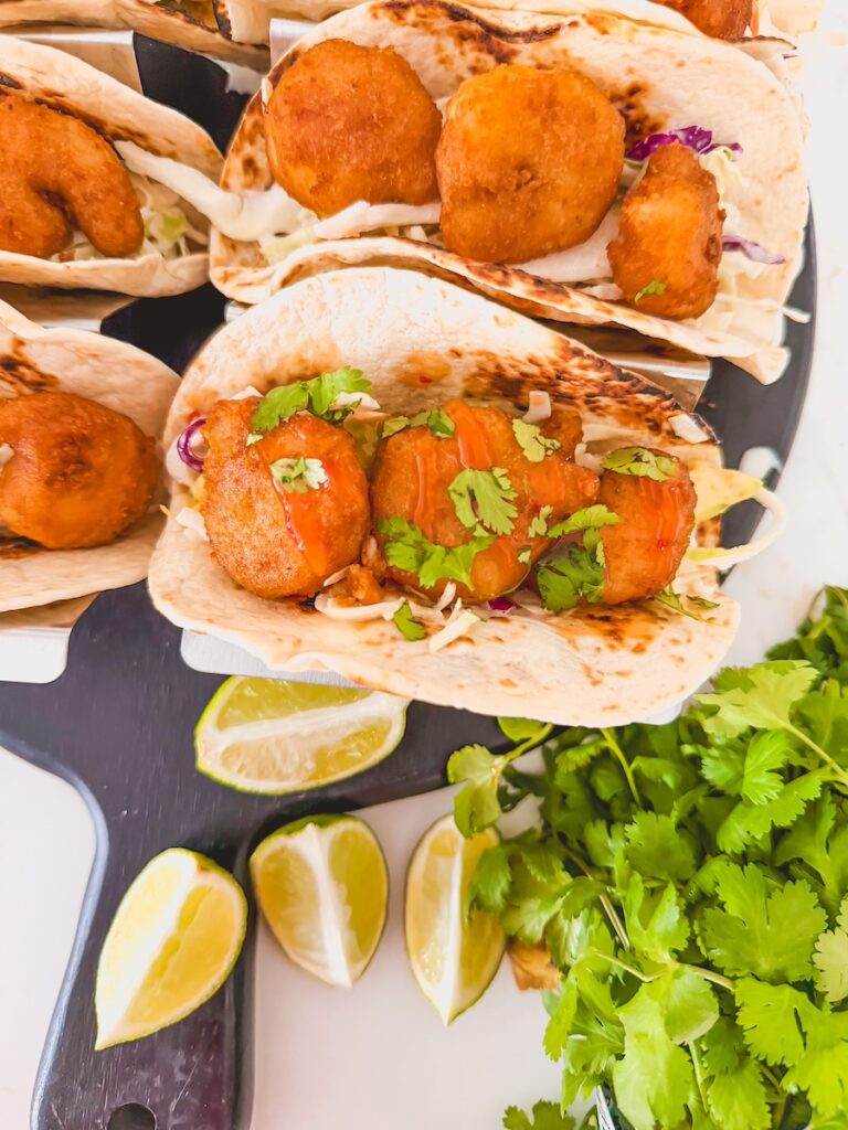 close up of beer battered shrimp taco with lime and cilantro