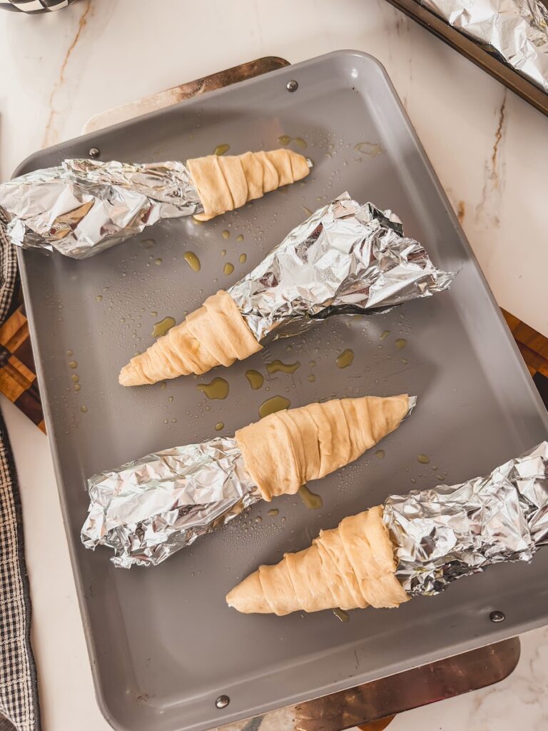 crescent dough wrapped around aluminum foil 
