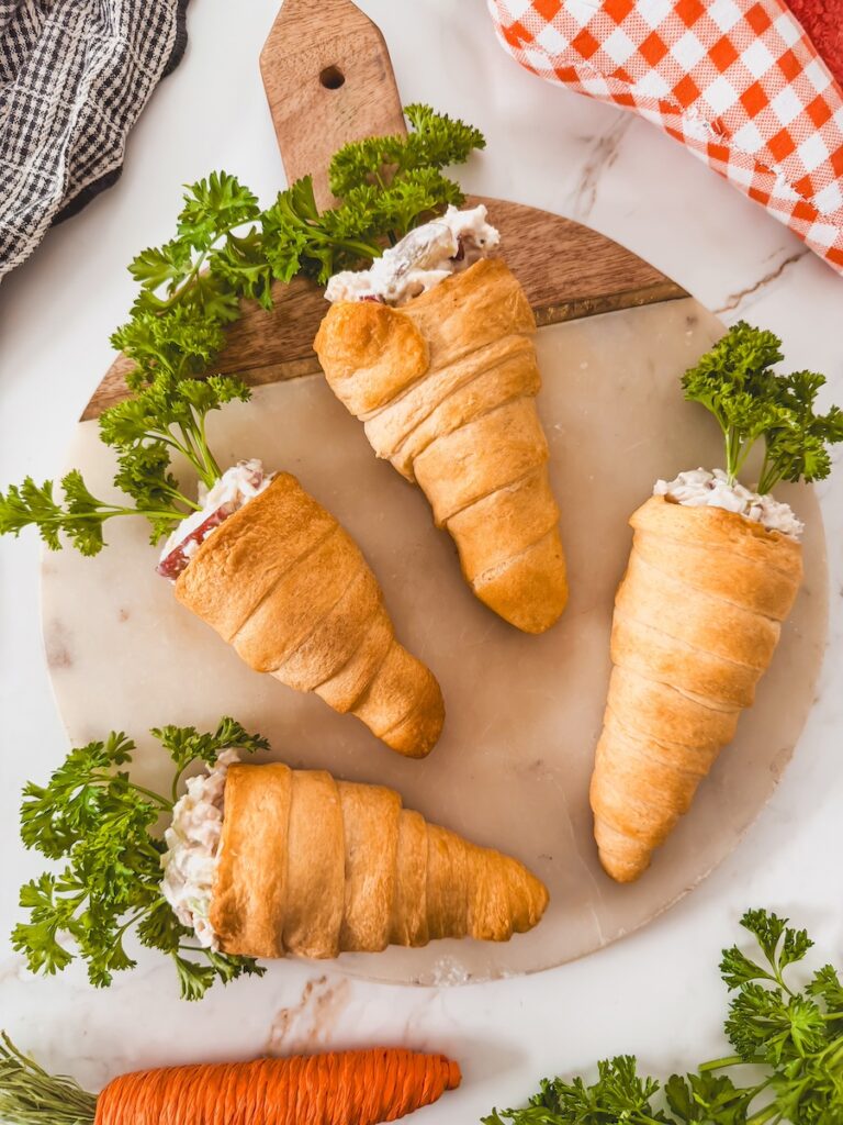 wood board with chicken salad carrot crescents