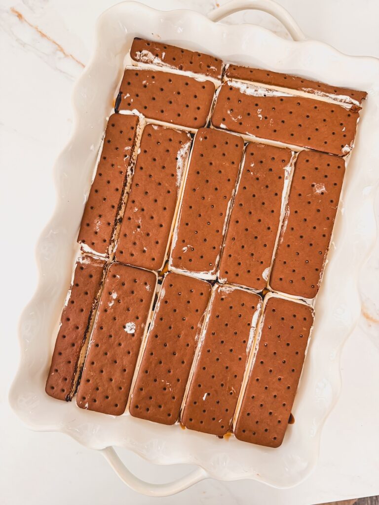 another layer of ice cream sandwiches added on top of peanut butter and fudge drizzled in baking dish