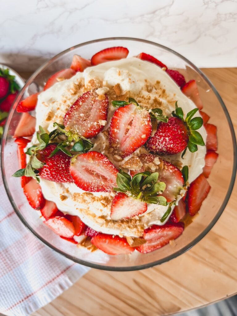 birds eye view of strawberry shortcake trifle in glass trifle on wooden board