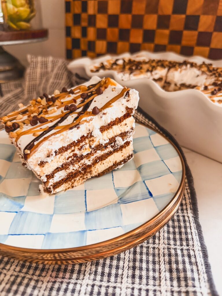 Slice of ice cream sandwich cake on plate with ice cream sandwich cake in baking dish in background