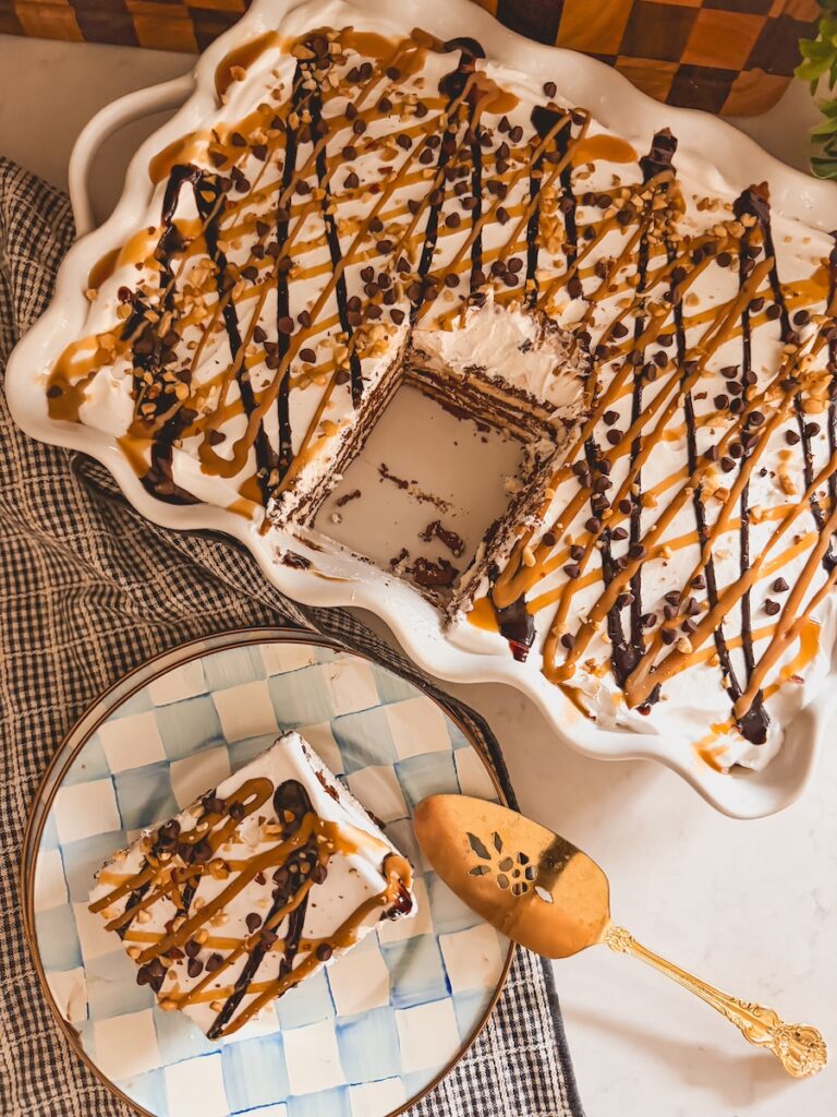 overhead view of ice cream sandwich cake in baking dish with one slice removed onto a plate with serving utensil