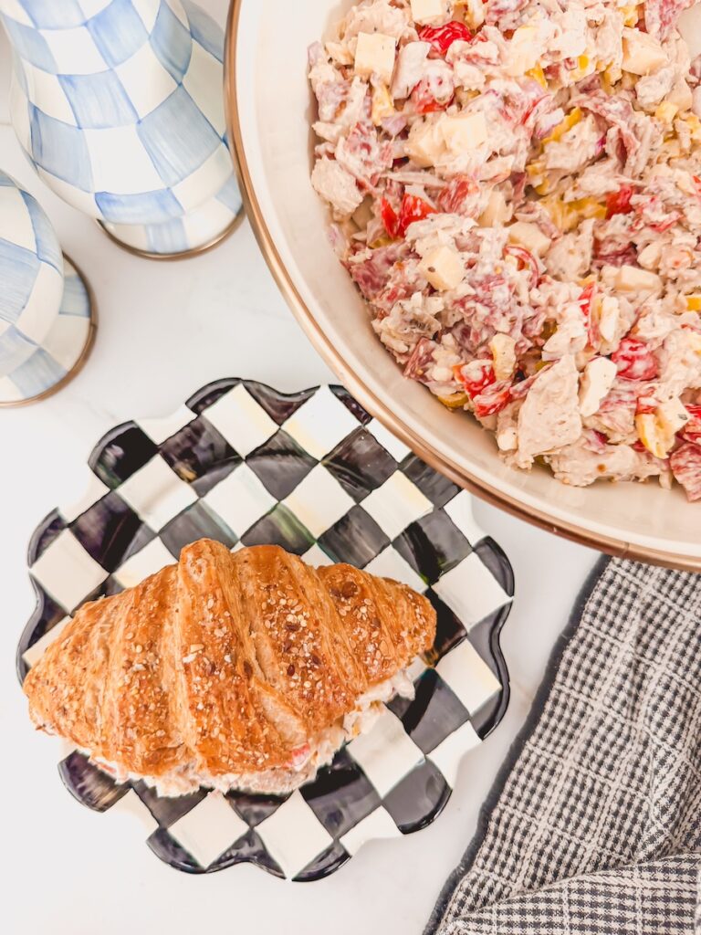 italian grinder croissant next to bowl of chicken salad