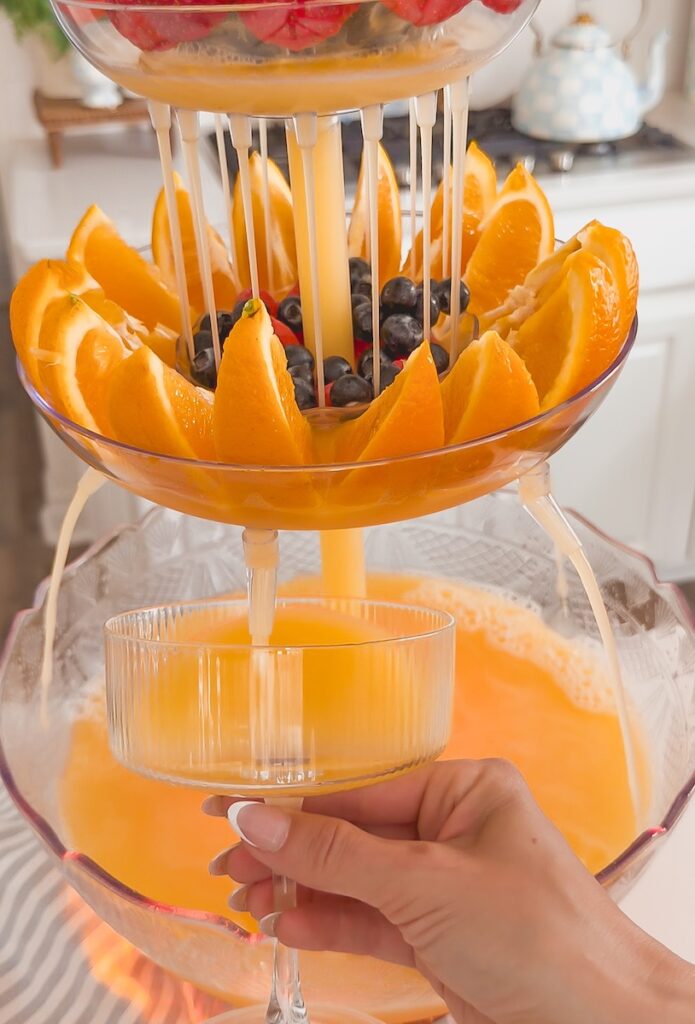 mimosa drink tower with glass of mimosa