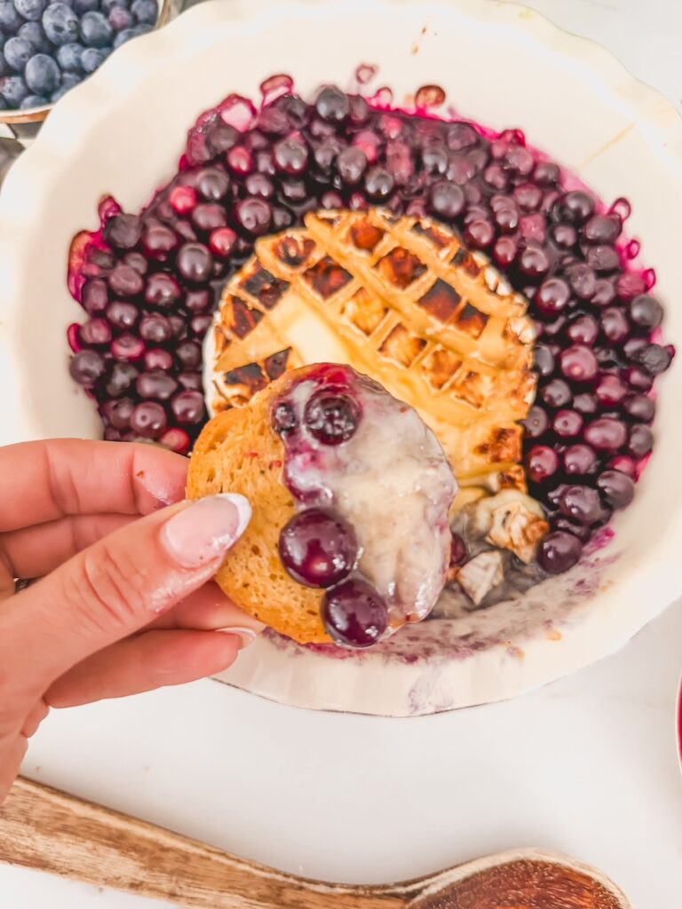 scoop of blueberry baked brie on baguette slice