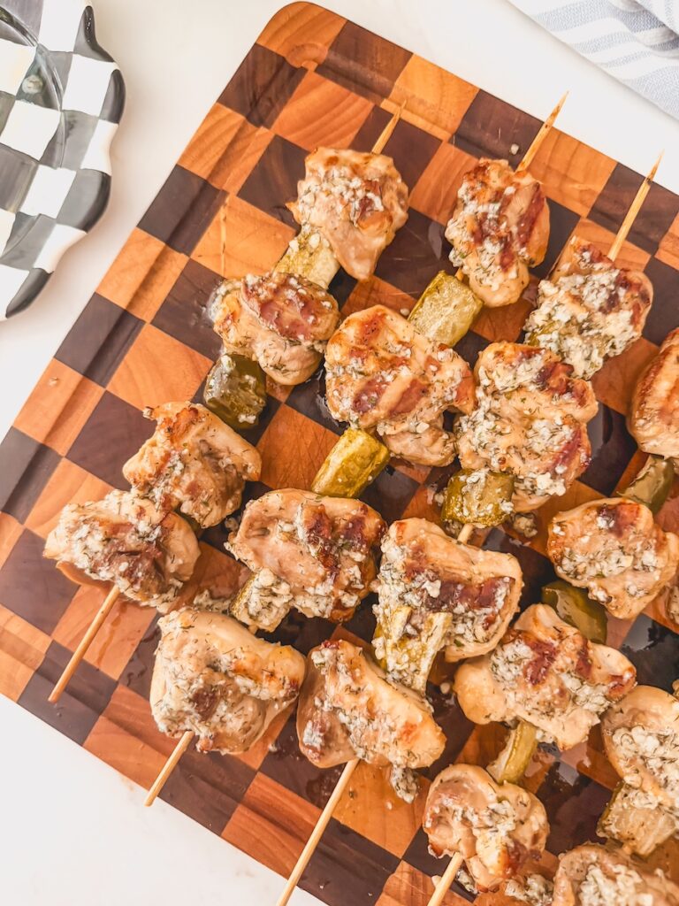 grilled dill pickle ranch chicken skewers on wood board
