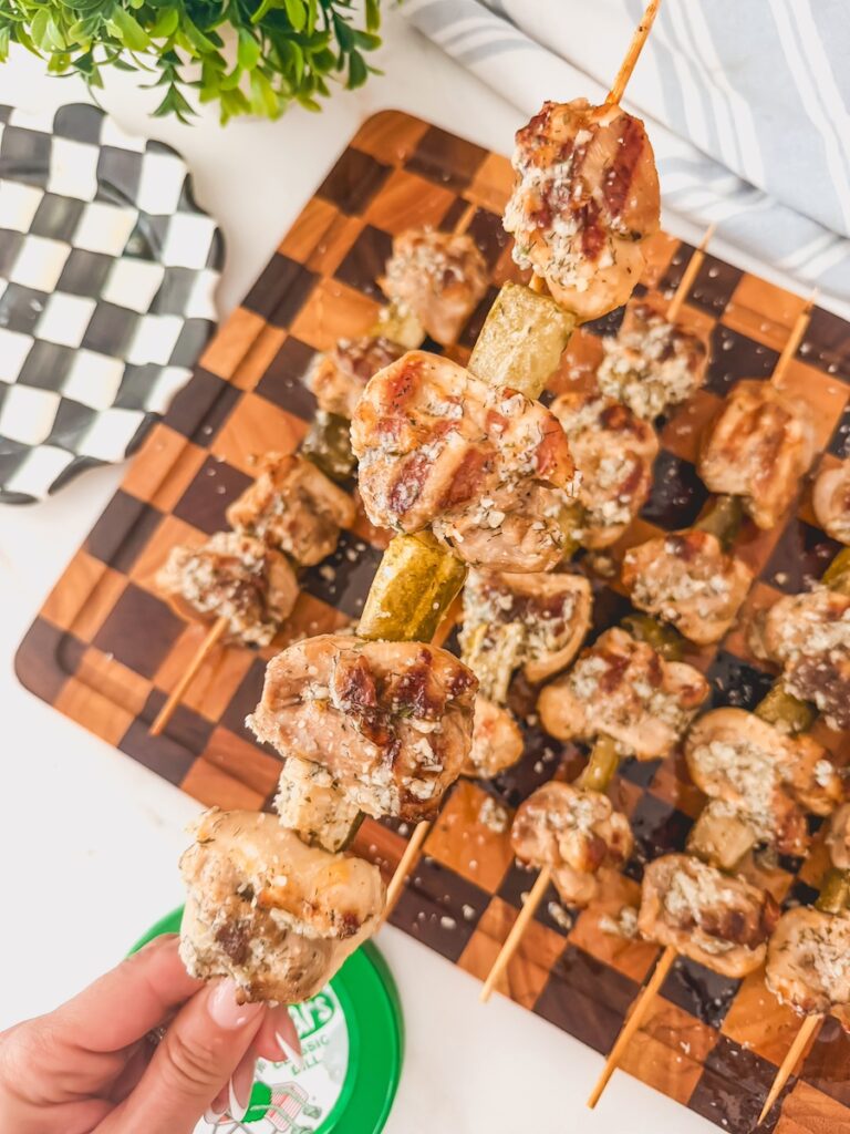 dill pickle ranch chicken skewers on a wood board