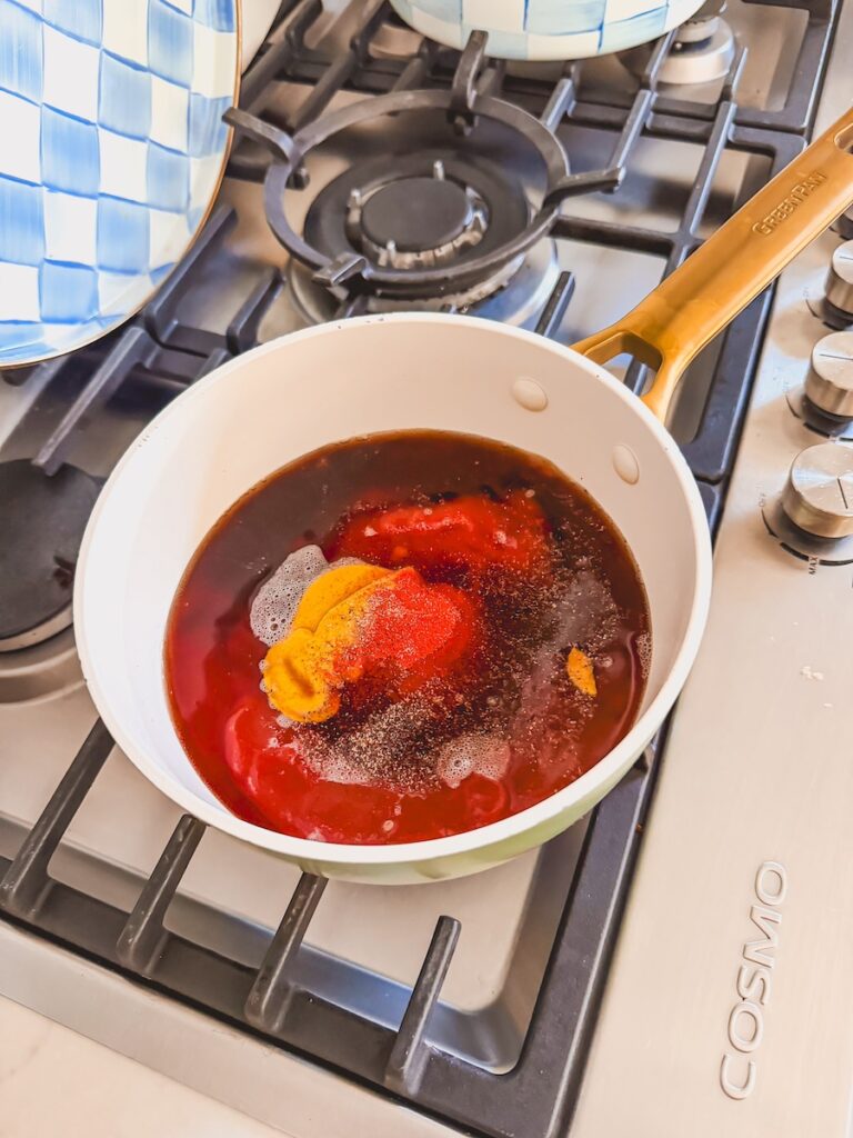A white saucepan with ingredients for homemade bbq sauce.