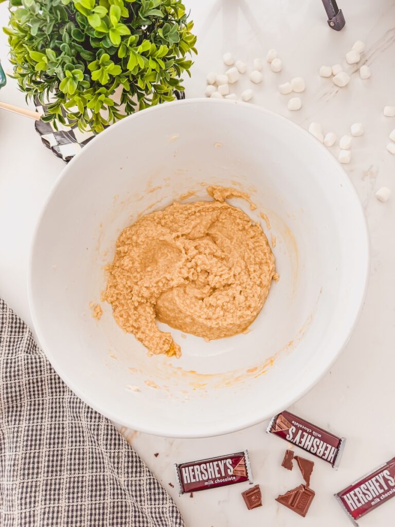 Creamed butter and sugar in a large white bowl for smores cookies.
