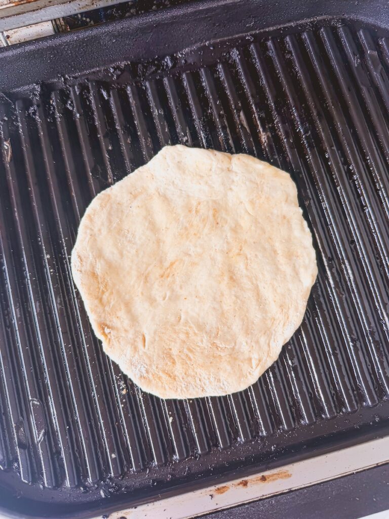 Pizza is placed onto the grill.