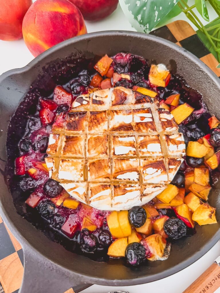 grilled brie melted in skillet with peached and blueberries