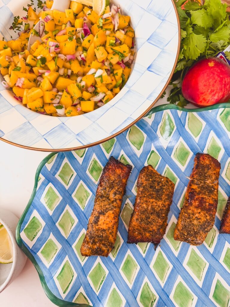 salmon cooked next to bowl of mango peach salsa