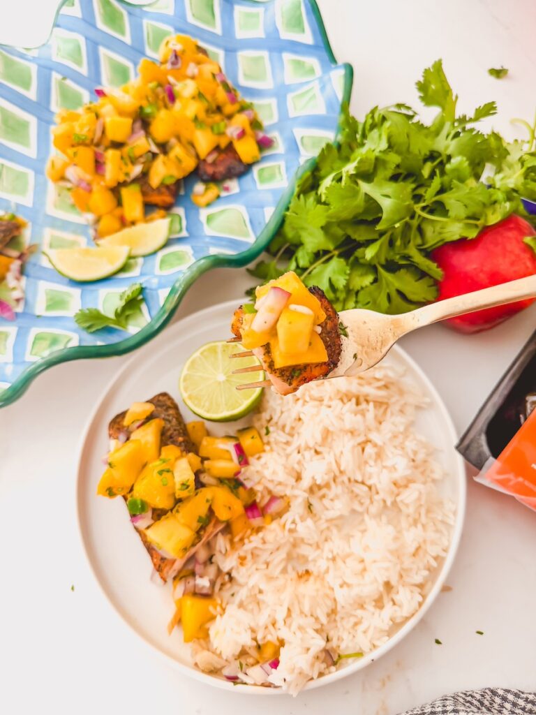 fork full of salmon with mango peach salsa