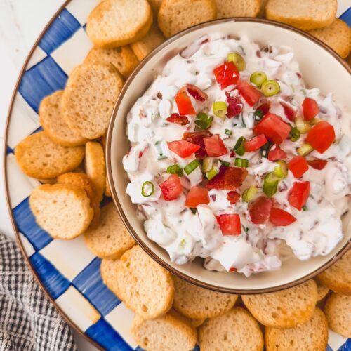 overhead view of bowl of blt dip in center of serving platter surrounded by crostini dippers