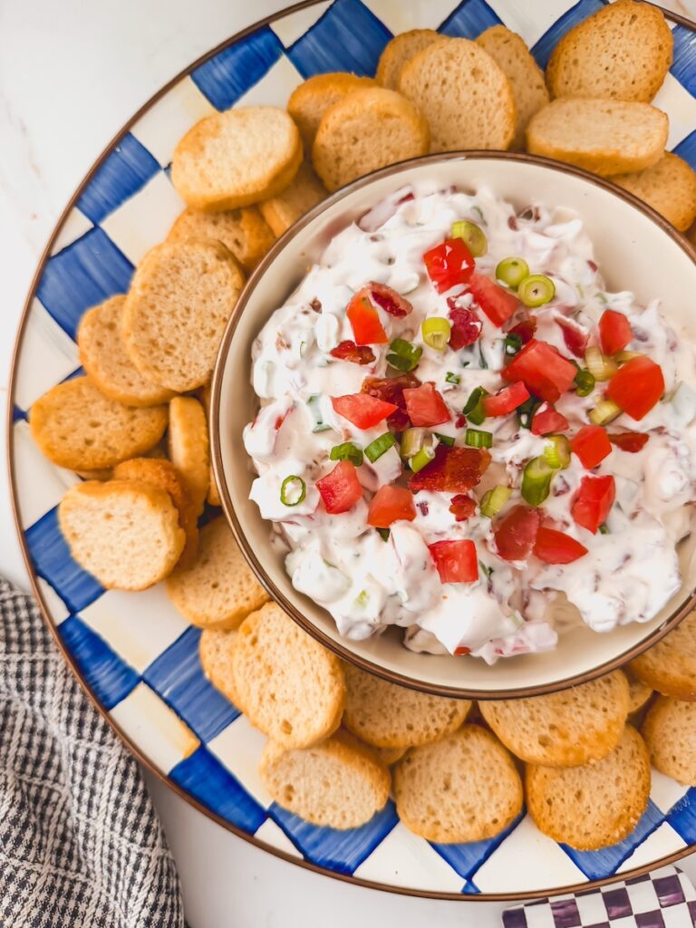 overhead view of bowl of blt dip in center of serving platter surrounded by crostini dippers
