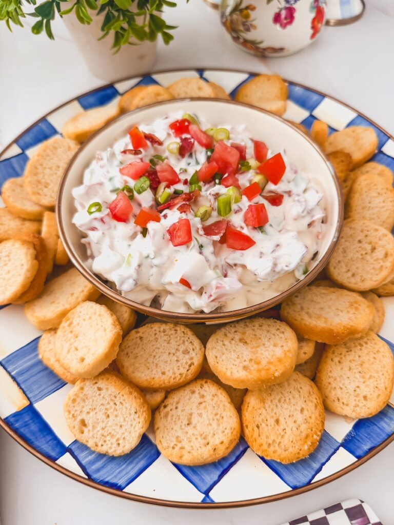 bowl of blt dip in center of serving platter surrounded by crostini dippers