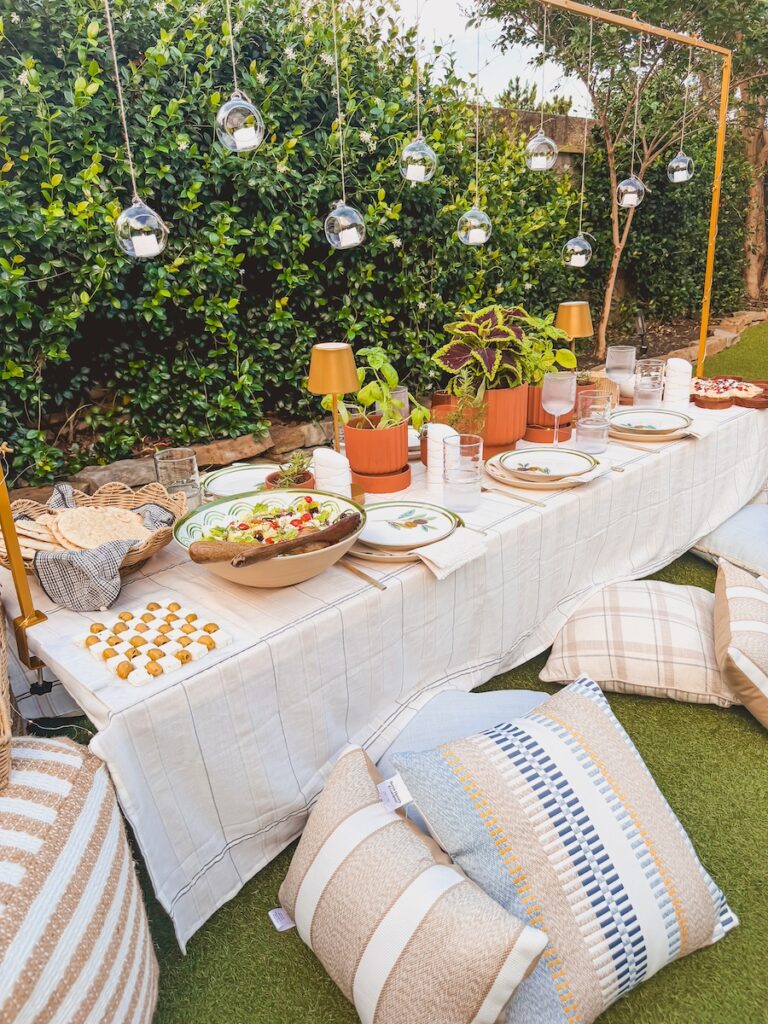 dinner party set up with low table , hanging lanterns and pillows