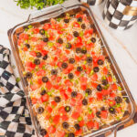 A glass baking dish with layered taco dip