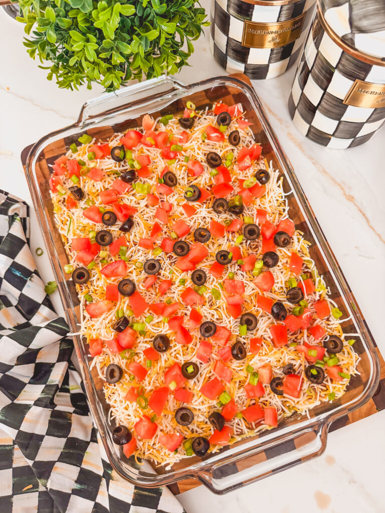 A glass baking dish with layered taco dip