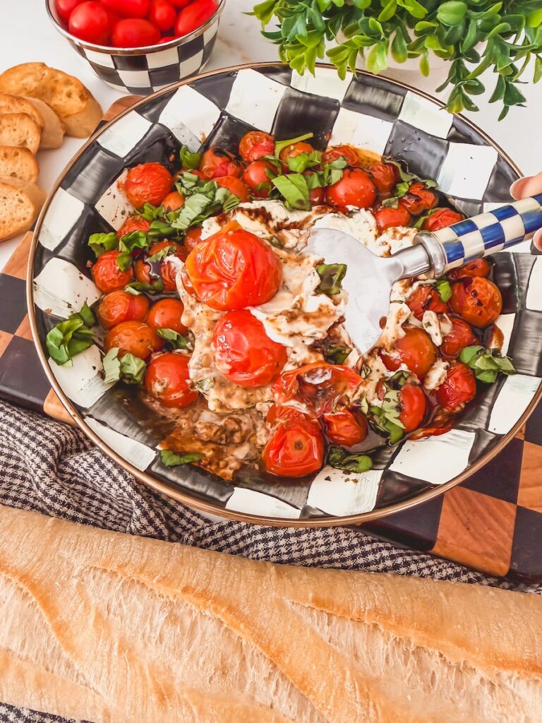 a spoon full of creamy boursin dip with roasted tomatoes, basil, and balsamic glaze