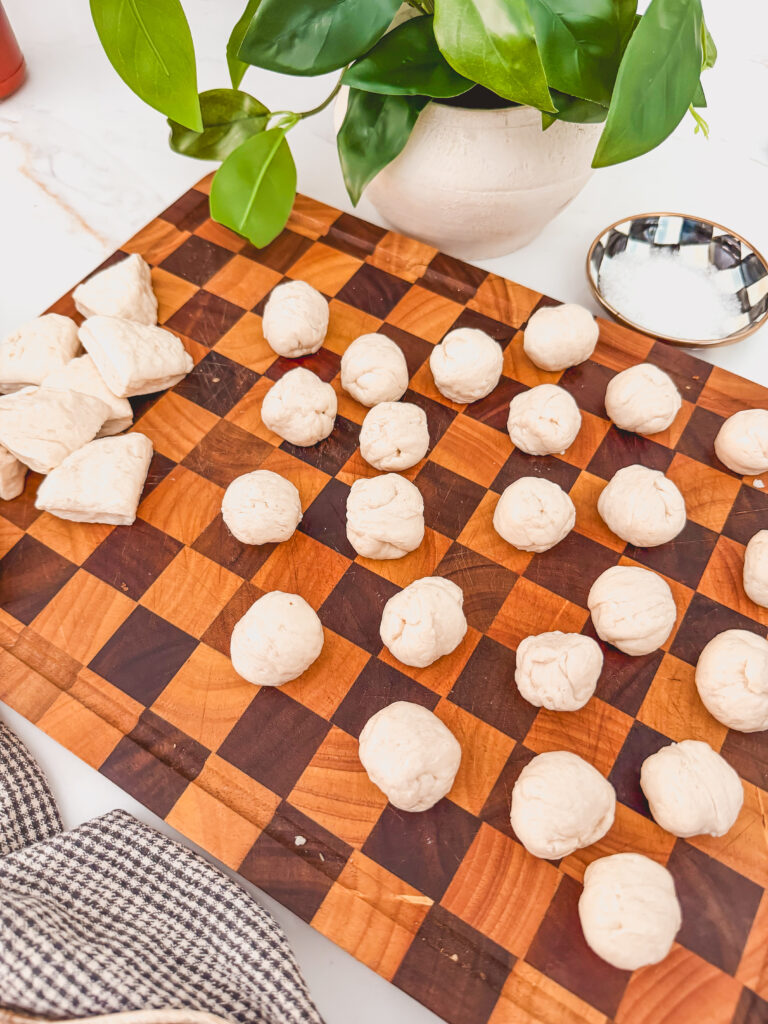 biscuit dough rolled into balls on cutting board