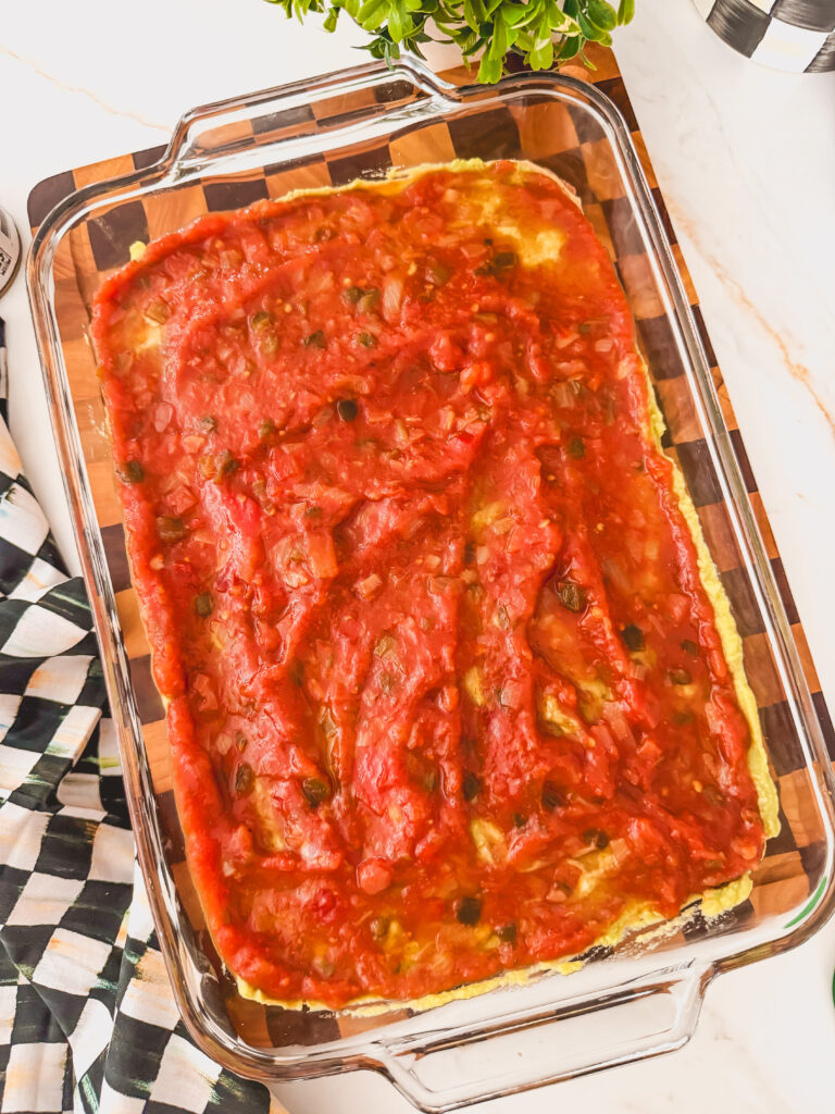 A glass baking dish with refried beans, guacamole, and salsa.