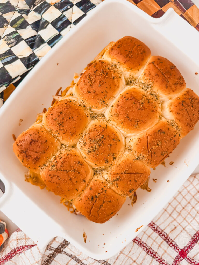 A white baking dish with baked chicken bacon ranch sliders.