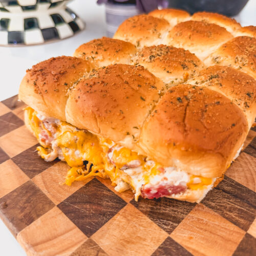 Close up of chicken bacon ranch sliders on a checkered cutting board.