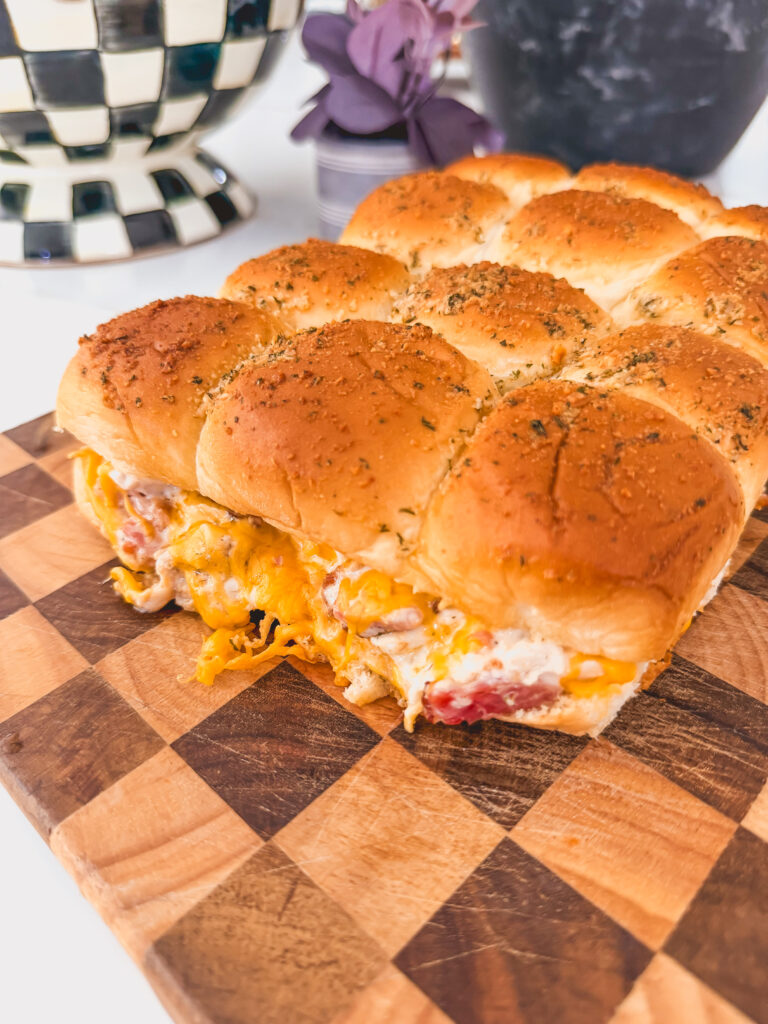 Close up of chicken bacon ranch sliders on a checkered cutting board.