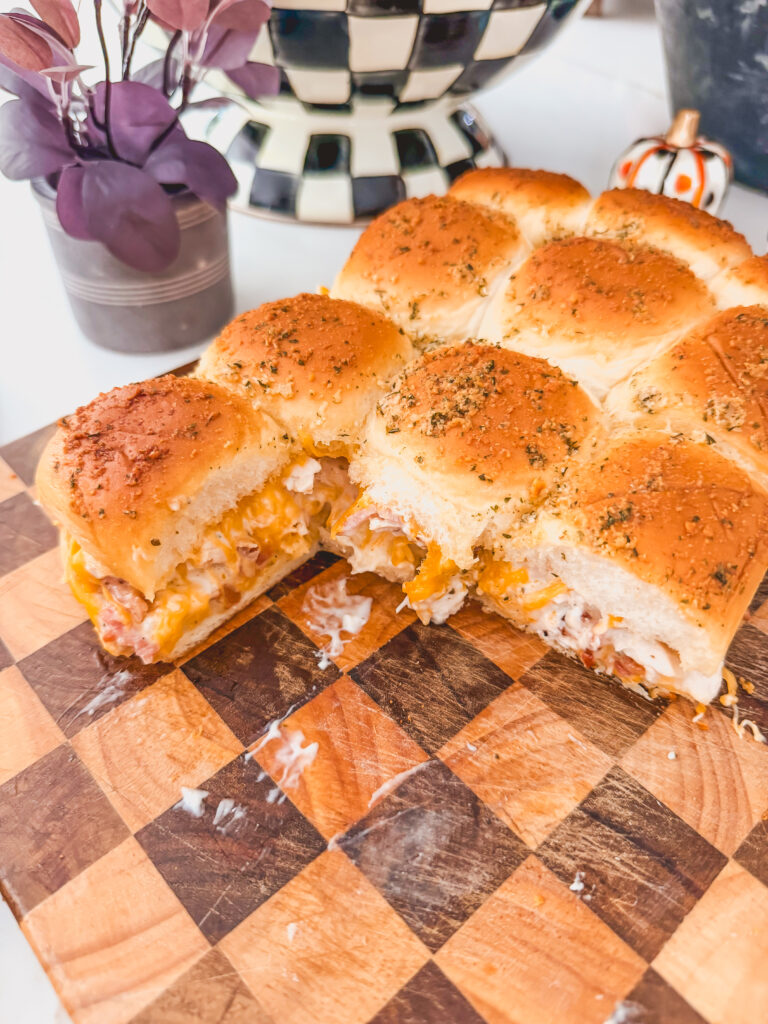 A side view of chicken bacon ranch sliders on a checkered cutting board.