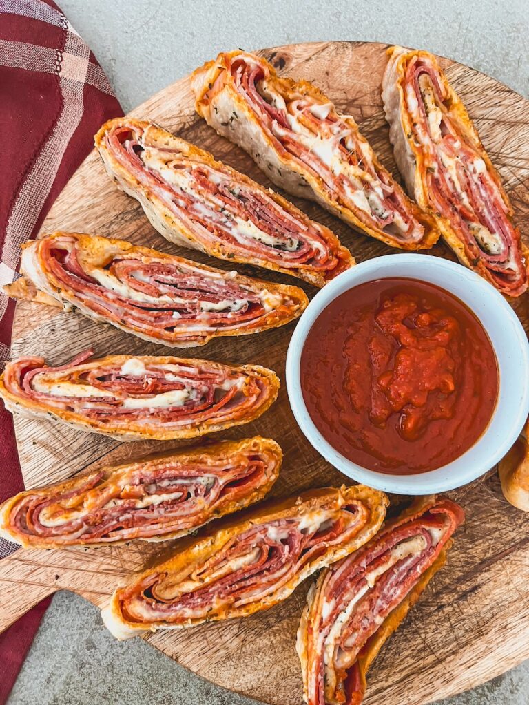 italian stromboli on wood platter with pizza sauce