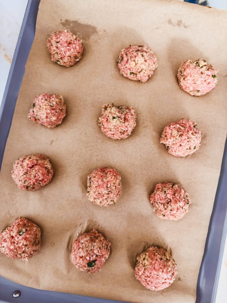 raw meatballs on baking sheet