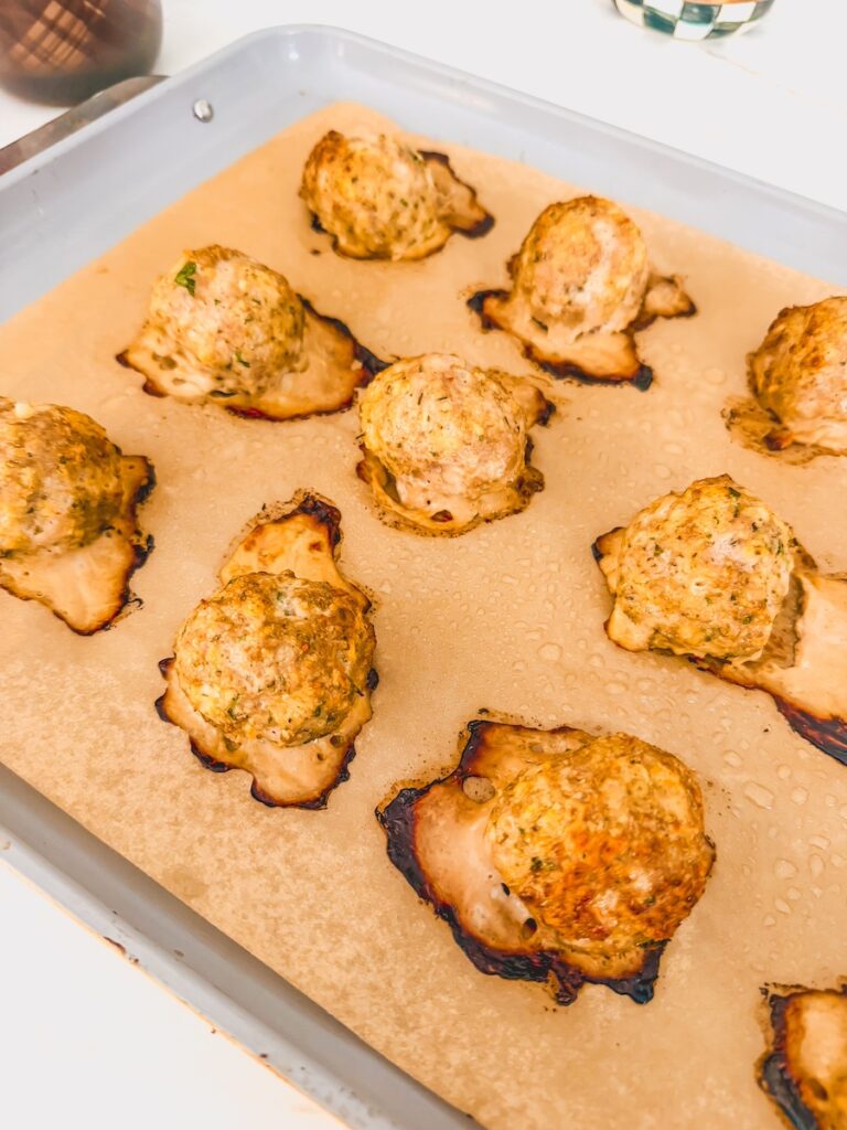 baked meatballs on parchment lined baking sheet