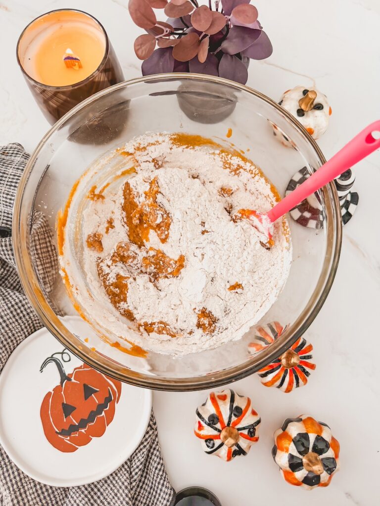 dry ingredients added to bowl of pumpkin blondie batter with red spatula