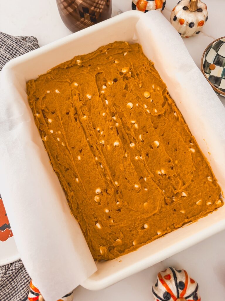 unbaked pumpkin blondie batter in baking dish with white chocolate chips