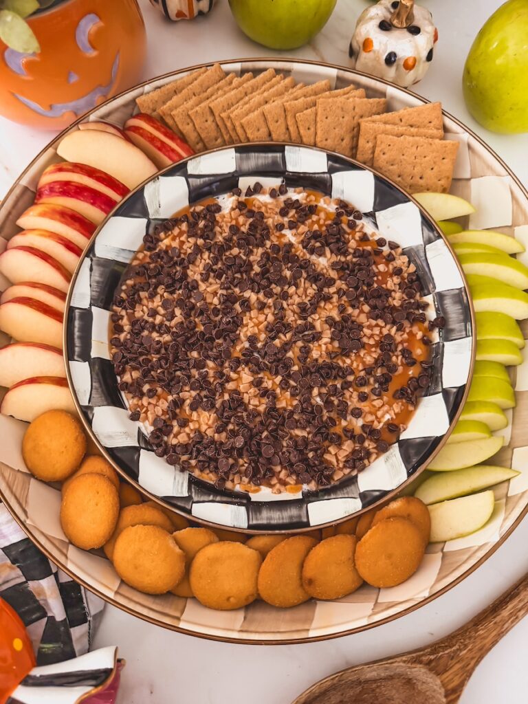 caramel apple cheesecake dip served alongside apple slices, graham crackers, vanilla wafers