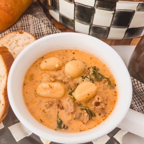 A white bowl with Italian sausage gnocchi soup.