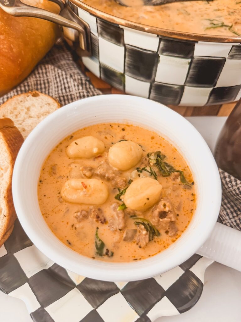 A white bowl with Italian sausage gnocchi soup.