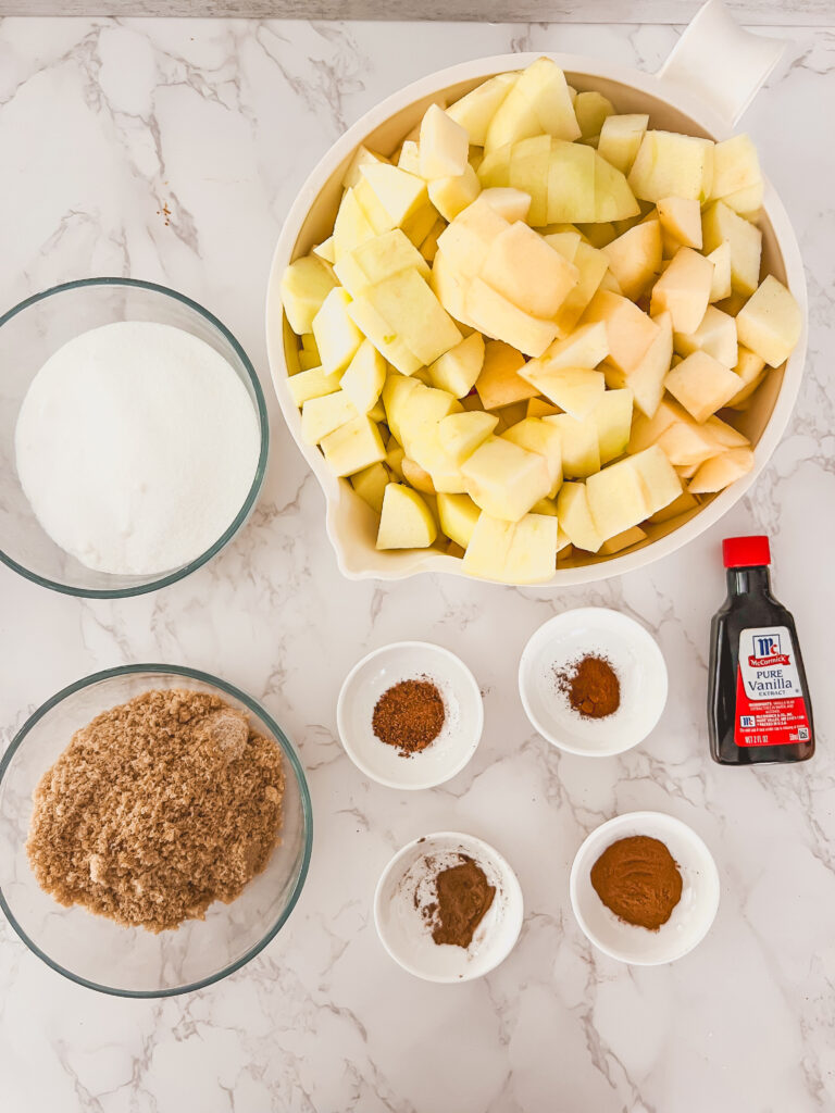 pumpkin apple butter ingredients on counter in glass and white bowls