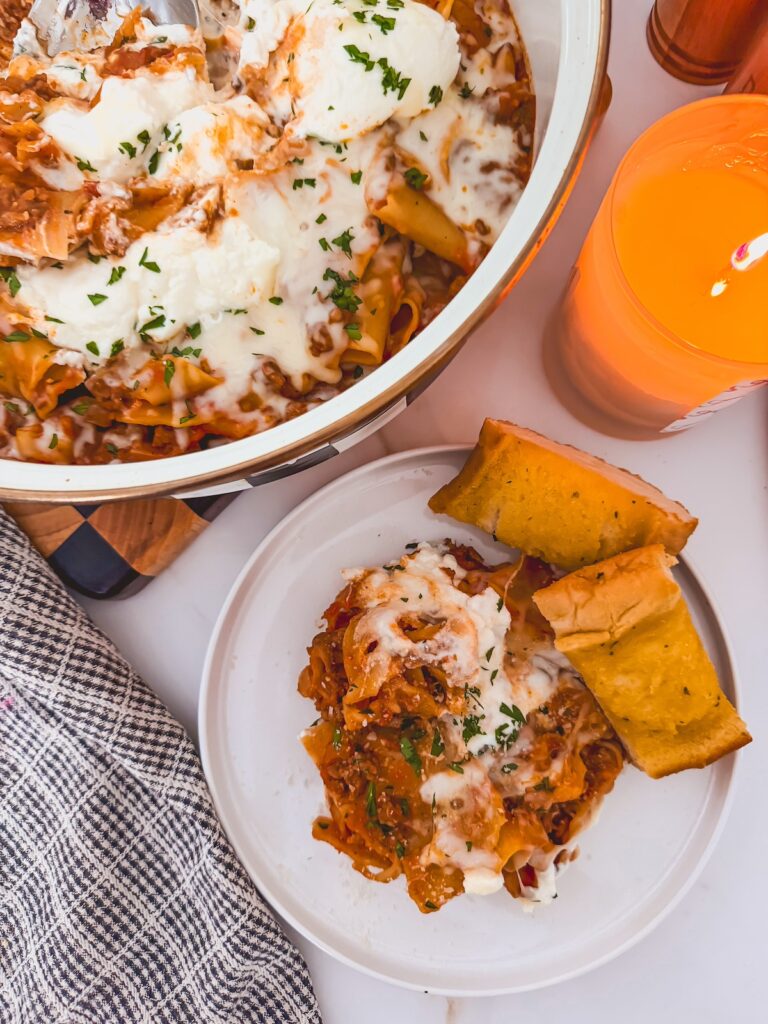 plate of one pan lasagna and garlic bread next t skillet
