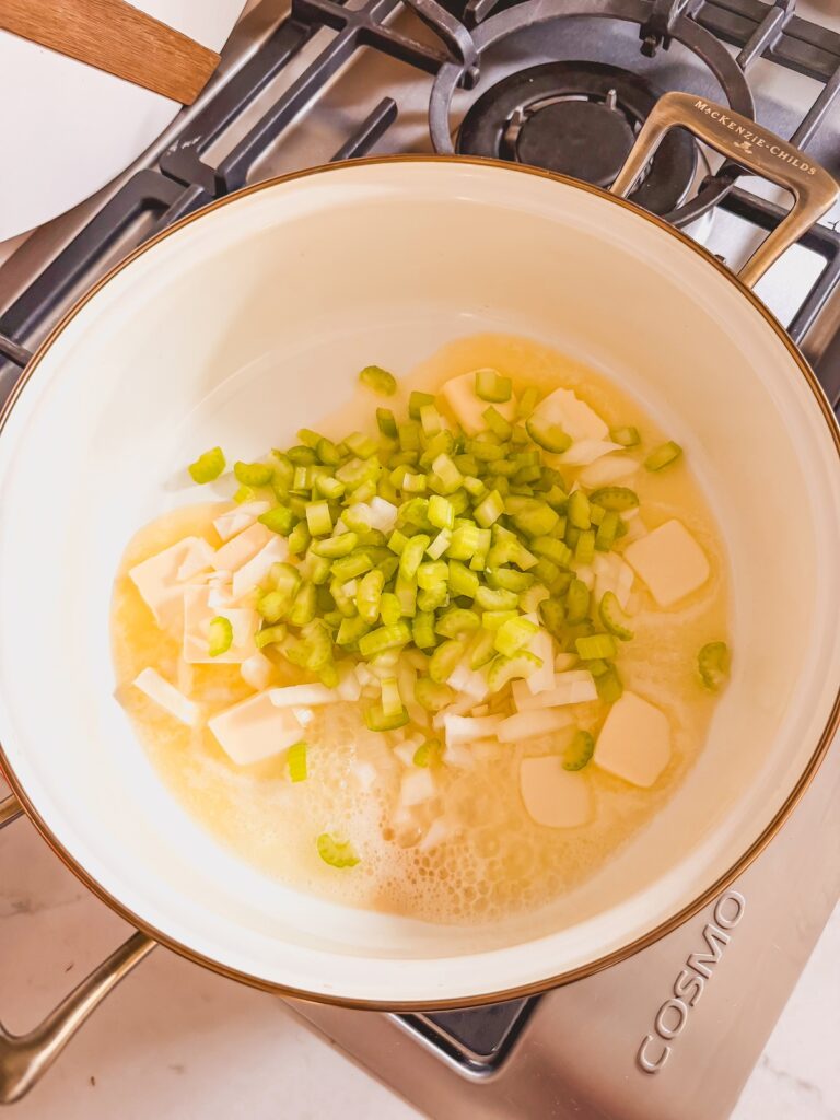 celery and onion sauteing in butter in pan on stove